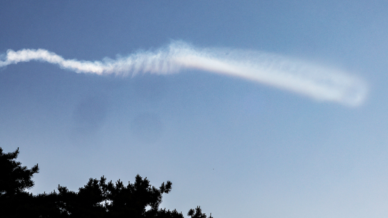 A contrail from a presumed North Korean intermediate-range ballistic missile Wednesday morning is seen over waters near Yeonpyeong Island in Incheon. [YONHAP]