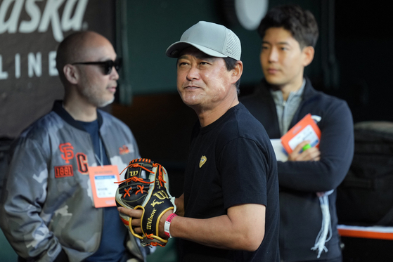 Lee Jong-beom, center, stands in the dugout before the game on Wednesday. [REUTERS/YONHAP]