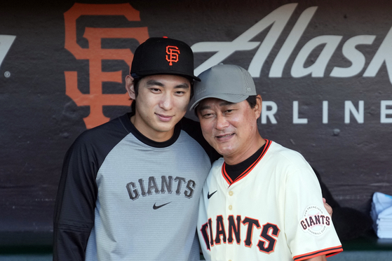 Lee Jung-hoo, left, and his father Lee Jong-beom pose for a photo before the game. [REUTERS/YONHAP]