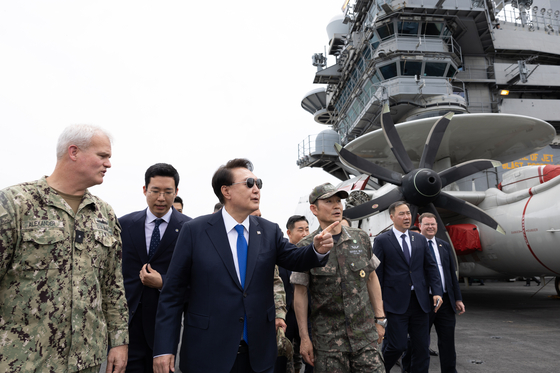 President Yoon Suk Yeol, center, visits the American nuclear-powered aircraft carrier USS Theodore Roosevelt (CVN-71), docked at a naval base in Busan on Tuesday. [PRESIDENTIAL OFFICE]