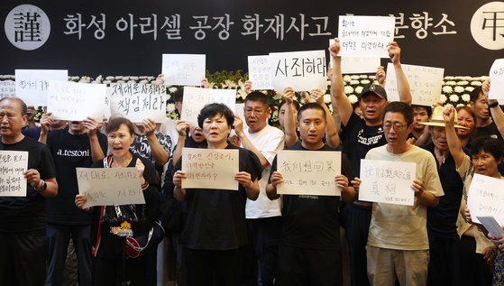 A group of family members of the victims of the deadly fire at lithium battery manufacturer Aricell’s plant in Hwaseong hold a press conference at the memorial altar at Hwaseong City Hall in Gyeonggi Sunday, demanding a thorough investigation into the tragedy that killed 23 workers. [YONHAP]