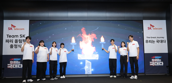 From left: Swimmer Hwang Sun-woo, weightlifter Park Hye-jeong, fencer Yoon Ji-su, handball player Kang Kyung-min, fencers Gu Bon-gil, Song Se-ra and Oh Sang-uk pose for a photo with the T-torch at SK-T Tower in central Seoul on Saturday. [YONHAP]