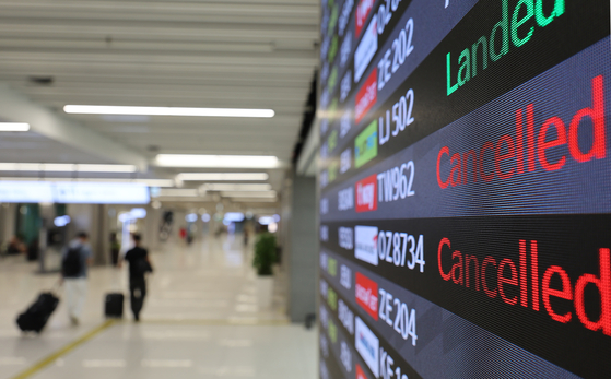 An arrival board at Gimpo International Airport informs passengers of delays and cancellations in flight schedules on Sunday as monsoon rain and strong winds disrupted flight operations in the country’s southern regions such as Busan and Jeju Island. [YONHAP]