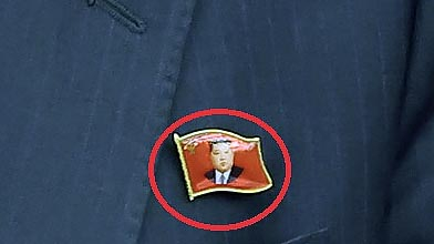 A North Korean official is seen wearing a pin featuring the portrait of North Korean leader Kim Jong-un in a photo carried by the North’s official Korean Central News Agency on Sunday. [YONHAP]