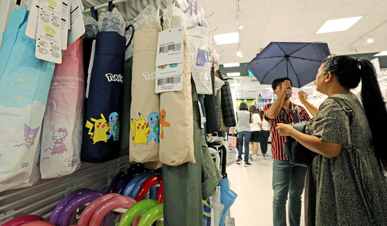 Tourists look at umbrellas at a shop in Seoul on June 28. [NEWS1]