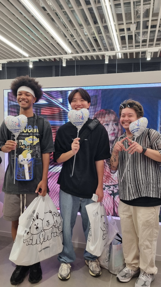 NewJeans fans pose for photos after buying goods from the pop-up store that opened on June 26 in Shibuya, Japan. [YOON SO-YEON]