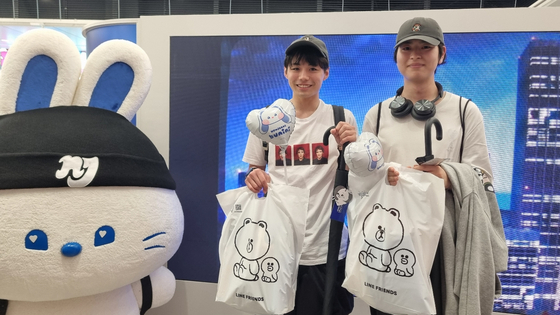 NewJeans fans pose for photos after buying goods from the pop-up store that opened on June 26 in Shibuya, Japan. [YOON SO-YEON]