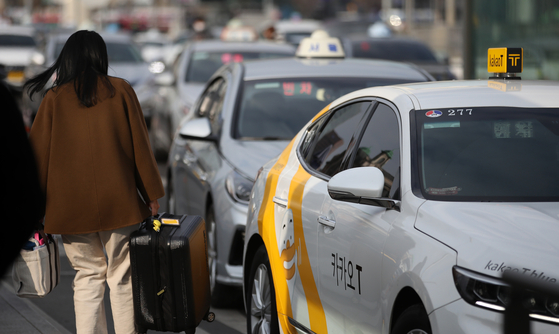 A passenger takes a taxi at Seoul Station in Jung District, central Seoul. [NEWS1]