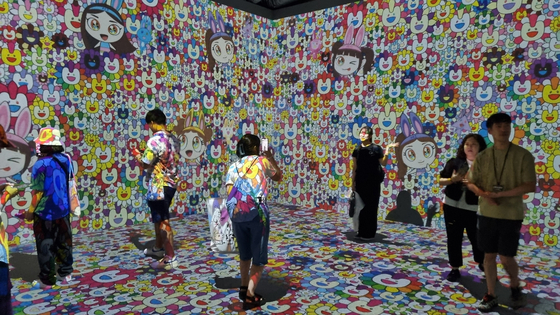 Customers take pictures at the media art section of girl group NewJeans' pop-up store held at the Line Friends Square in Shibuya, Japan, on June 26. [YOON SO-YEON]