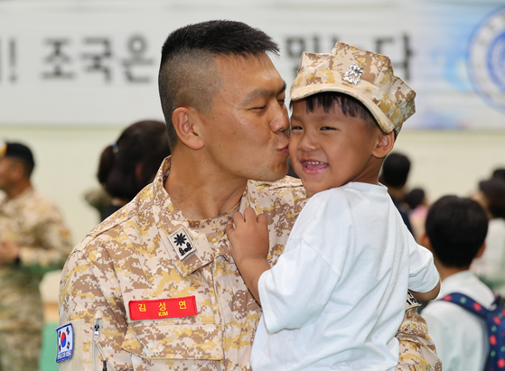 A soldier kisses his son’s cheek during a farewell ceremony in Incheon on Tuesday before his deployment as a member of the Akh Unit, a Korean military force in the United Arab Emirates (UAE). The latest rotation of the 140-member strong Akh Unit will be deployed to the Middle East for eight months. The soldiers will participate in military cooperation with the UAE and protect Korean nationals in the Middle East. Akh means brother in Arabic. [YONHAP] 