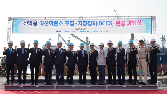HMM officials pose during the commemorative ceremony to deploy its new eco-friendly technology at Mokpo, South Jeolla, on Monday. [HMM]