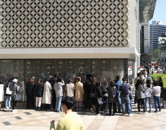 Customers wait as the line to enter the Chanel store snakes around the Lotte Department Store flagship branch in Jung District, central Seoul, on Wednesday. Speculation has grown that the French luxury brand will soon raise prices, as it did in France on May 11. [YONHAP]