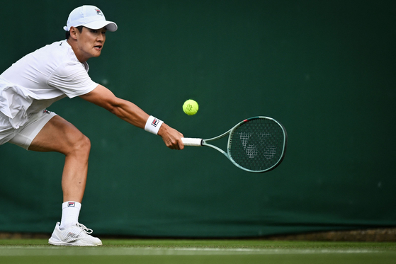 Korea's Kwon Soon-woo returns the ball to Denmark's Holger Rune during their men's singles match on the second day of the 2024 Wimbledon Championships at The All England Lawn Tennis and Croquet Club in London on Tuesday. [AFP/YONHAP]