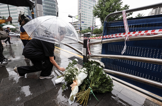 A citizen leaves flowers at the scene of the accident that killed nine people on Monday night near Seoul City Hall on Tuesday. [KIM SUNG-RYOUNG]