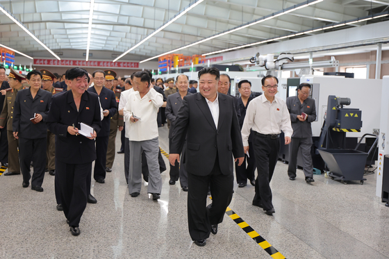 North Korean leader Kim Jong-un, center, inspects a major defense industrial plant Tuesday in a photo provided by its official Korean Central News Agency Wednesday. The inspection took place right after the final day of a plenary meeting of the eighth Central Committee of the Workers' Party of Korea. [YONHAP]