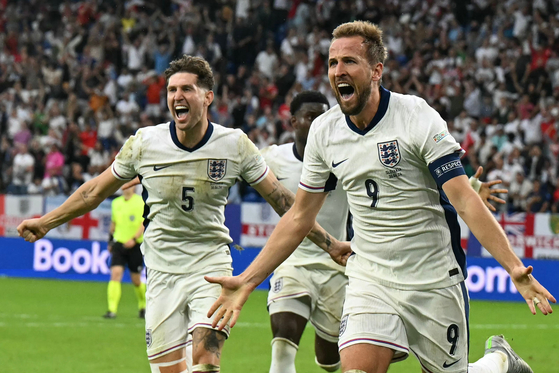 Bayern Munich forward Harry Kane of England, right, celebrates scoring during the round of 16 Euros match against Slovakia at the Arena AufSchalke in Gelsenkirchen, Germany on June 30. [AFP/YONHAP] 