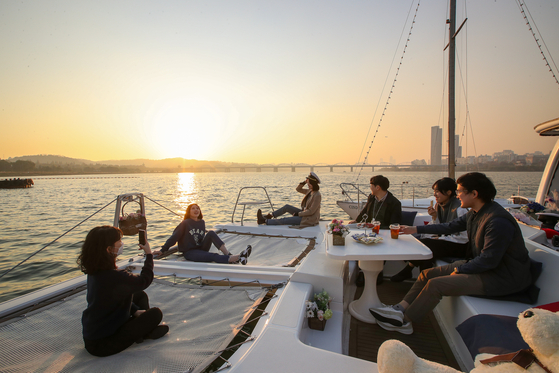 People enjoy a sunset view on a yacht tour of the Han River. [JOONGANG ILBO]