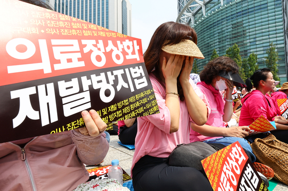 Patients and their families shed tears during a rally calling for an end to doctors' strikes and legal protections to prevent a future medical staffing vacuums in front of Bosingak, a bell pavilion in central Seoul, on Thursday. [JOONGANG ILBO]