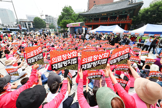 Protesters rally to demand legislation of a bill to prevent medical staffing vacuums in front of Bosingak, a bell pavilion in Jongno District, central Seoul, on Thursday morning. [KIM JONG-HO]
