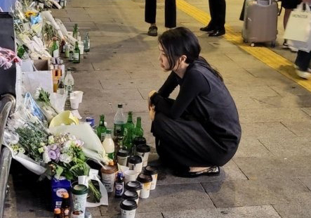 First lady Kim Keon Hee is seen on Wednesday laying flowers and reading condolence letters at the scene of the fatal car crash that killed nine people near Seoul City Hall on Monday in this picture uploaded on an online community website. [NEWS1]