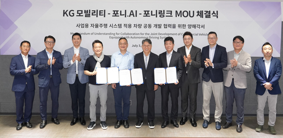KG Mobility Chairman Kwak Jea-sun, center, and executives of Pony.ai and PonyLink take a photo after signing an agreement to cooperate in developing self-driving cars in Seoul on Wednesday. [KG MOBILITY]