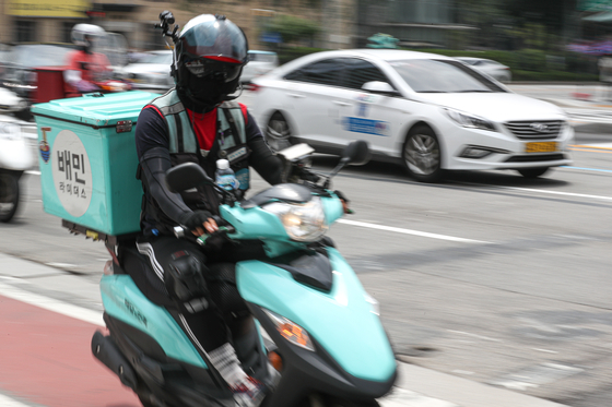 A delivery man rides a motorcycle to deliver food to respective customers. [NEWS1]