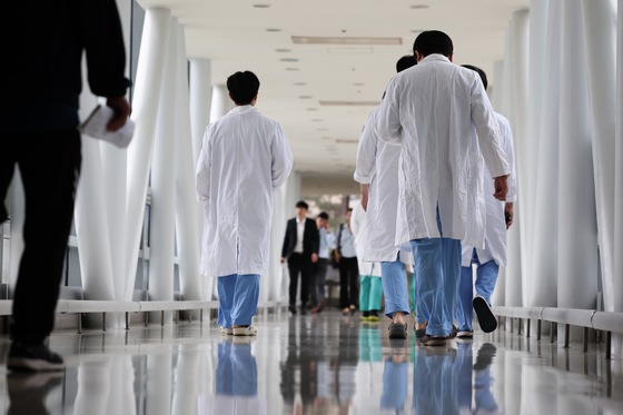 Medical professionals walk inside a corridor at a general hospital in Seoul on Monday. [YONHAP] 