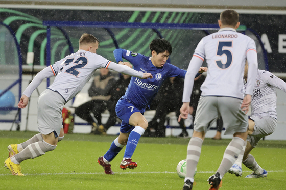 Ghent's Hong Hyun-seok, center, fights for the ball during the first leg of the Europa Conference League against Istanbul Basaksehir at KAA Gent stadium in Ghent, Belgium on March 9, 2023. [AP/YONHAP]