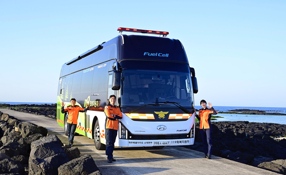 Firefighters from the Jeju Fire Safety Headquarters pose for a photo in front of Hyundai Motor's hydrogen-powered bus. [HYUNDAI MOTOR]