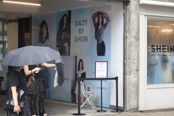 Passersby take a look at the Chinese fast-fashion company Shein's pop-up store in Seongsu-dong in Seongdong District, eastern Seoul, on Monday. [YONHAP]