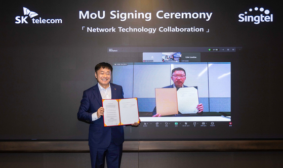 Kang Jong-ryeol, SK Telecom's head of ICT Infra division, left, and Tay Yeow Lian, Singtel's managing director of networks, pose after signing a memorandum of understanding to advance network technologies at SK Telecom's headquarters in central Seoul. [SK TELECOM]