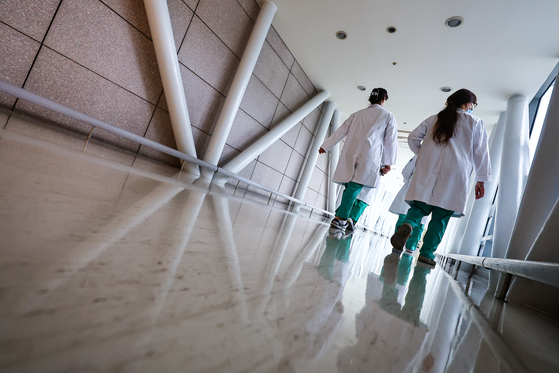 Two medical professionals walks inside a general hospital in Seoul on Monday. [YONHAP]