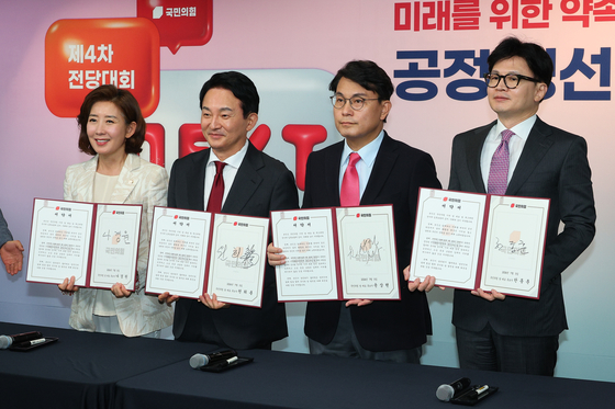 From right, former interim chief Han Dong-hoon, Rep. Yoon Sang-hyun, former Land Minister Won Hee-ryong and Rep. Na Kyung-won, all contenders for the People Power Party leadership, take part in a ceremony pledging for a “fair” race ahead of the party’s national convention later this month at the PPP headquarters in Yeouido, western Seoul, on Friday. [YONHAP]