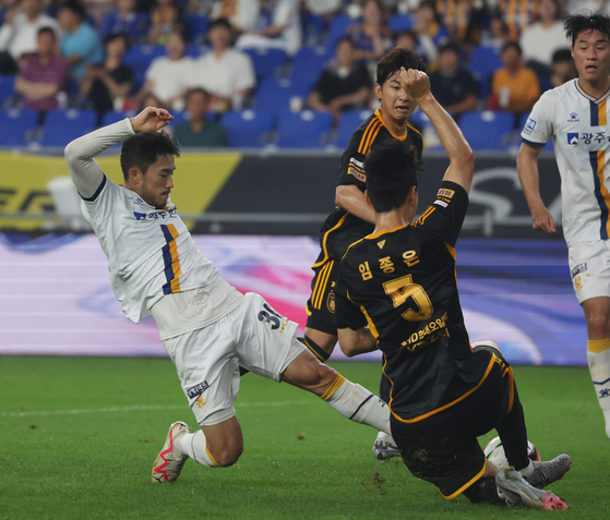 Ulsan HD defender Lim Jong-eun, right, vies for the ball with Gwangju FC midfielder Choe Kyoung-Rok during a K League 1 match at Munsu Football Stadium in Ulsan on Wednesday. [YONHAP] 