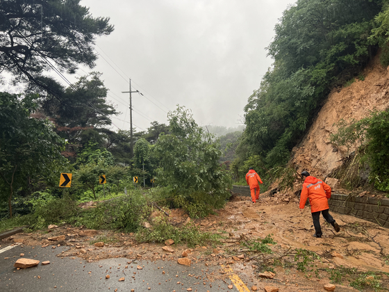 Fire authorities visit a damaged road in Andong, North Gyeongsang, following a heavy rain on Monday. [NORTH GYEONGSANG FIRE HEADQUARTERS]