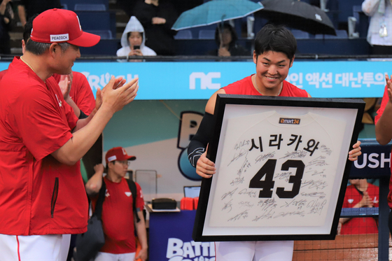 Keisho Shirakawa, right, receives a commemorative photo from SSG Landers manager Lee Sung-yong at Changwon NC Park in Changwon, North Gyeongsang on July 2. [YONHAP]