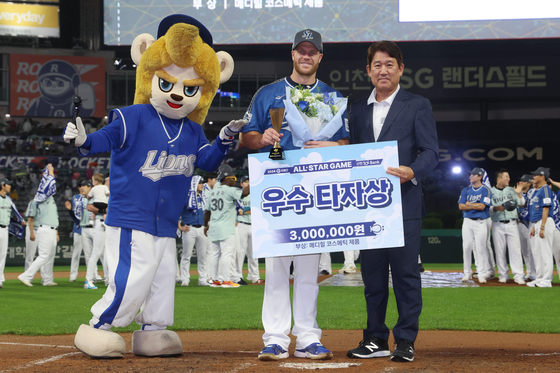 David MacKinnon, center, takes a photo after receiving the Outstanding Batter Award after the 2024 KBO All-Star Game at SSG Landers Field in Incheon on Saturday. [YONHAP]