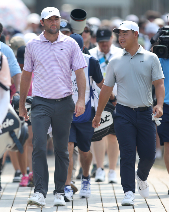 Scottie Scheffler and Tom Kim walk across the bridge on the 18th hole during the third round of the Charles Schwab Challenge at Colonial Country Club in Fort Worth, Texas on May 25.  [GETTY IMAGES]