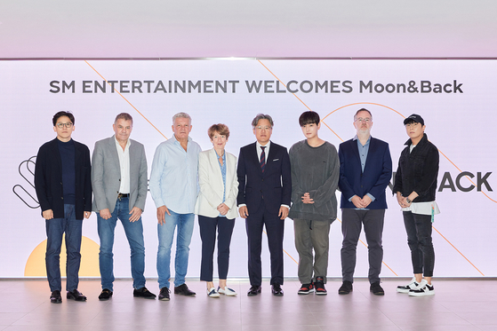 Representatives of SM Entertainment and Moon&Back Media pose for the camera after signing a memorandum of understanding in November 2023. [SM ENTERTAINMENT]