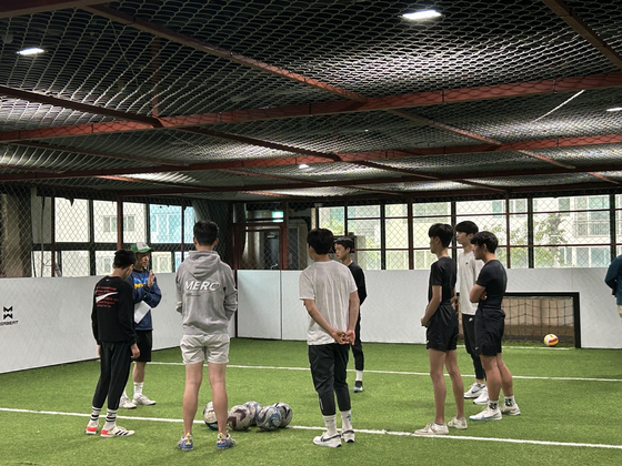 A coach speaks with players. [HOMELESS WORLD CUP]