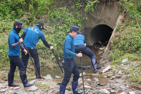 Police officers from the Jeonbuk Provincial Police Agency search for a student who went missing on Wednesday around the area near Iksan Stream on Friday. [YONHAP]