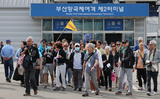 Group tourists from a cruise ship that set sail from Japan arrive at Busan Port in May. [JOONGANG ILBO]