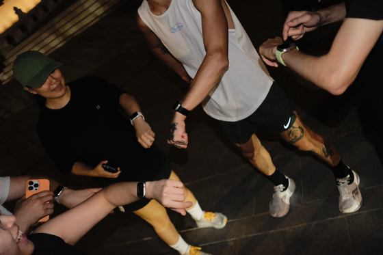 Runners set their workouts before heading out on the town. [HAN STRIDE]