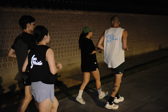 The group sets out along the stone wall surrounding Gyeongbuk Palace in central Seoul. [HAN STRIDE]