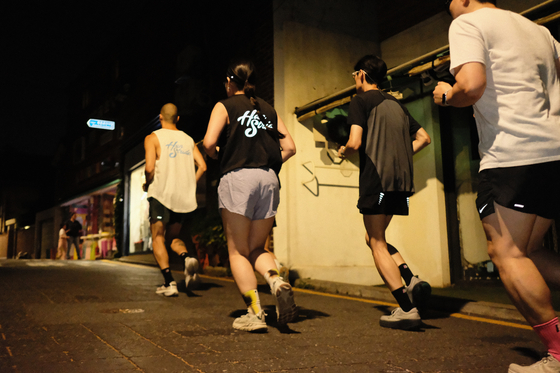 Runners make their way through a neighborhood in central Seoul on a weeknight in June. [HAN STRIDE]