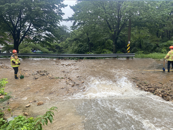 Firefighters respond to a flooded road in Geoje, South Gyeongsang on Sunday. [GYEONGSANGNAM-DO PROVINCIAL FIRE HEADQUARTERS] 