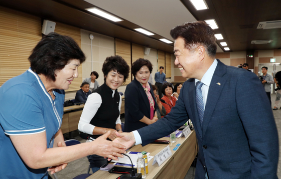 Jeju Governor Oh Young-hoon holds hands with haenyeo representatives during a meeting to establish a national haenyeo association at the Jeju Provincial Self-Government Special Office on June 26. (JEJU PROVINCE SELF-GOVERNMENT SPECIAL OFFICE)