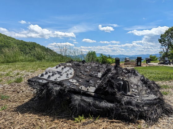  In a photo from Brett Tingley, space debris that was found at the Glamping Collective luxury campground in the mountains west of Asheville, N.C., May 22, 2024. The hunk of metal found on a remote trail in the luxury camping resort came from a SpaceX Dragon capsule, NASA said. [Brett Tingley via The New York Times]