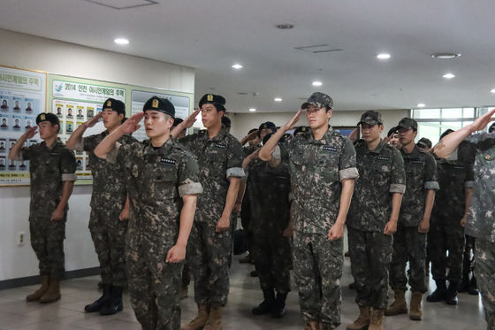 Soldiers from the Korea Armed Forces Athletic Corps (Kafac), including 17 players from K League 1 team Gimcheon Sangmu, salute during a discharge ceremony at the Kafac headquarters in Mungyeong, North Gyeongsang on Monday. The discharged football players will now return to their former clubs. [GIMCHEON SANGMU]