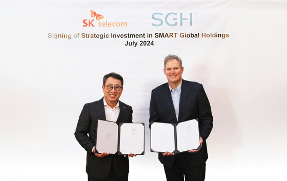SK Telecom CEO Ryu Young-sang, left, and Mark Adams, President and CEO of Smart Global Holdings, pose for a photo after signing an investment deal. [SK TELECOM]